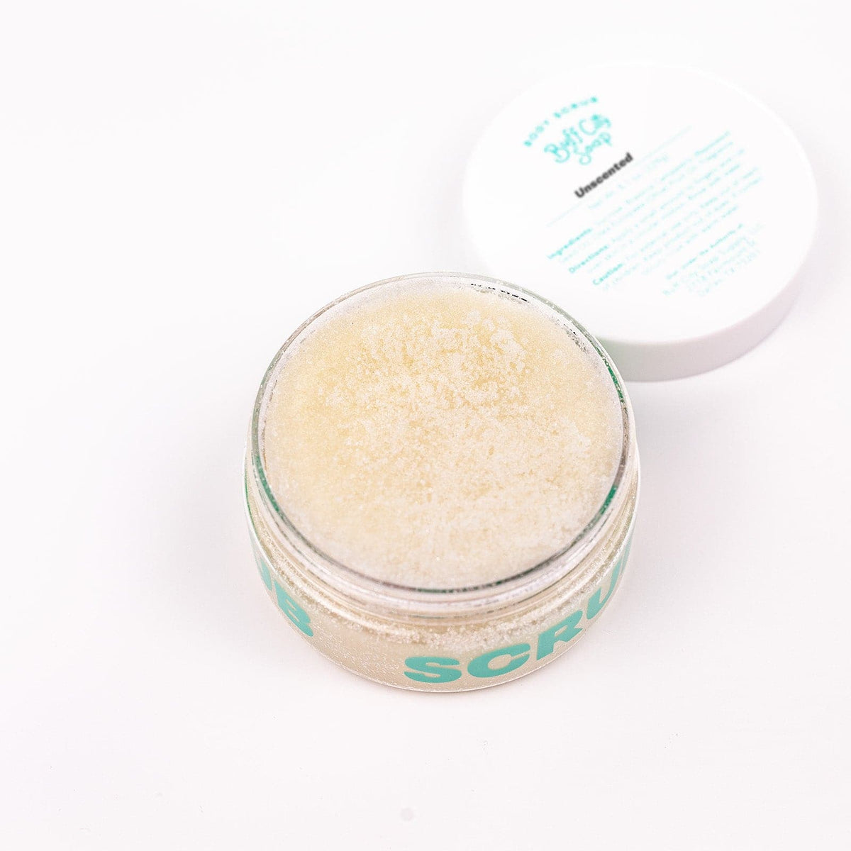 Open jar of Unscented Body Scrub with lid placed next to it