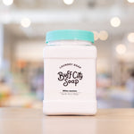 White Jasmine Laundry Soap with teal lid on wooden counter